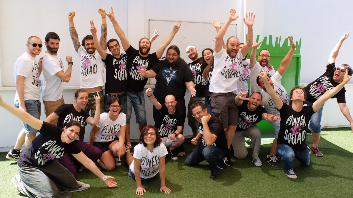Team picture outside with several people in different postures looking happy