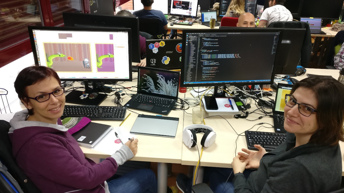 Maria & Esther working in front of their computers during a PIWEEK