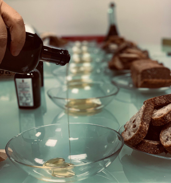 Imagen en la que se muestra una aceitera en primer plan poniendo aceite sobre un bol. En línea, varios bols con aceite.